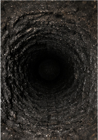 Chimney flue coated in creosote before sweeping